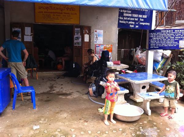 Children outside a wooden ticket office in Luang Prabang