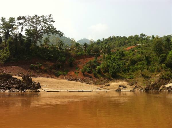 Ochre muddy river, sandy banks and lush green wooded hills