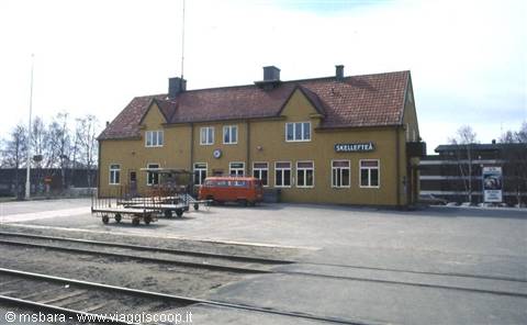 Skellefteå railway station, yellow building with red van and tracks