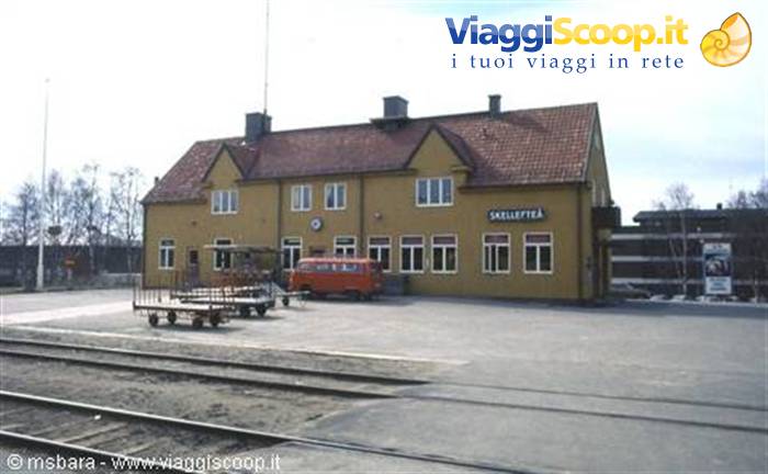 Skellefteå railway station, yellow building with red van and tracks