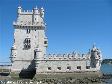 Belém Tower in Lisbon, white stone under blue sky, Tagus river nearby