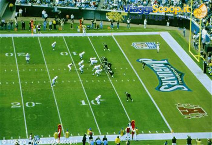 American football game at Jacksonville Jaguars stadium, crowded green field