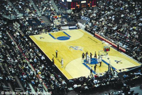Basketball game at Continental Airlines Arena, lit hardwood court among packed crowd