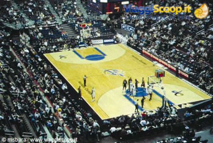 Basketball game at Continental Airlines Arena, lit hardwood court among packed crowd