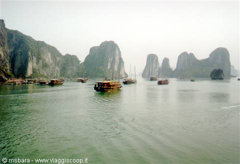 Wooden boat among limestone karsts in Ha Long Bay
