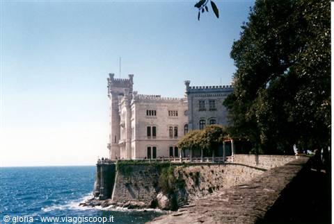 Miramare Castle overlooking the Adriatic Sea among green trees