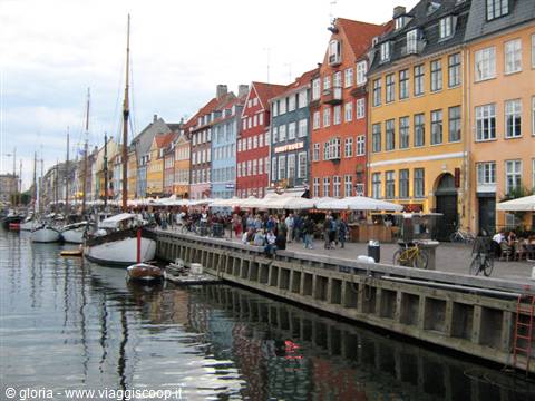 Nyhavn in Copenhagen: colorful townhouses, moored sailboats and umbrellas along the quay