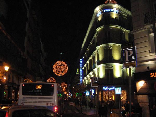 Bus 147 at night under Christmas lights near Hotel Preciados in Madrid