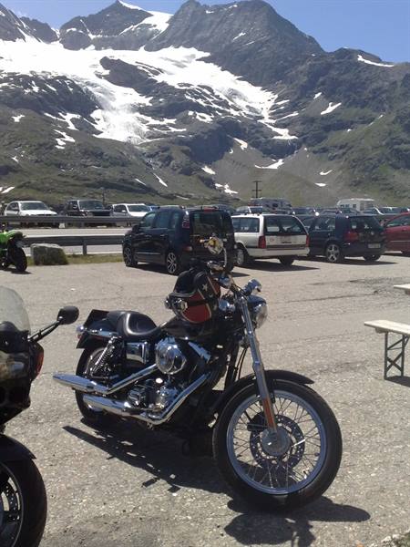Black Harley motorcycle parked beneath the Bernina pass glacier