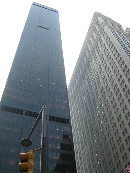 Dark glass skyscraper beside a light stone tower, New York