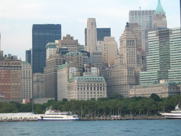 Ferry docked in front of Lower Manhattan skyscrapers, soft daylight