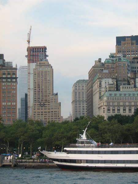 White ferry boat docked in front of the Lower Manhattan skyscrapers