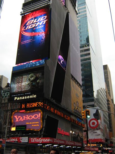 Times Square: skyscrapers covered with glowing Bud Light, Yahoo! and Walgreens signs