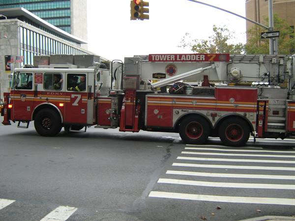 FDNY Tower Ladder 7 fire truck crossing an intersection with crosswalk