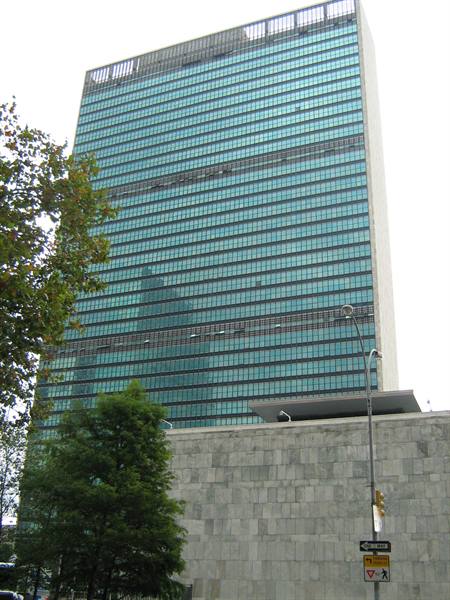 The glass Secretariat tower of the United Nations above the marble wall