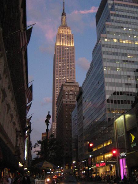 The Empire State Building lit up at dusk above New York skyscrapers