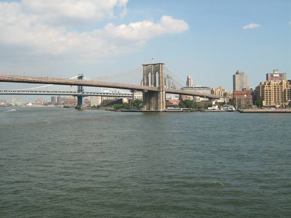 The Brooklyn Bridge of stone and steel over the East River, Manhattan behind