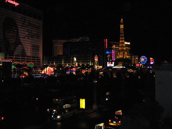 Las Vegas Strip at night: Flamingo neon sign and glowing Eiffel Tower replica