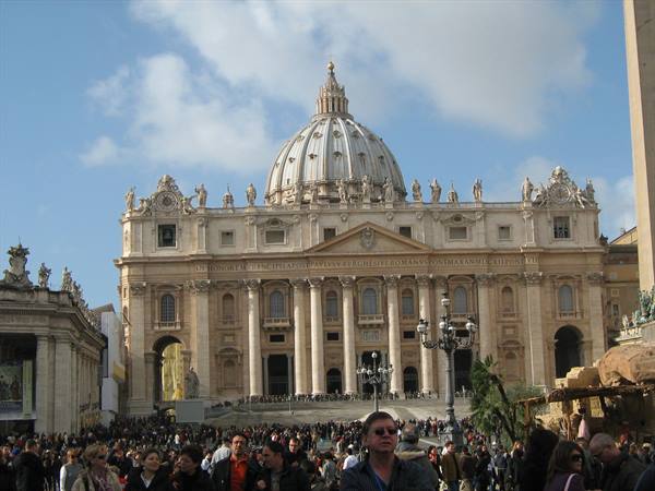 Crowd of tourists in front of St. Peter's Basilica facade and dome, Rome