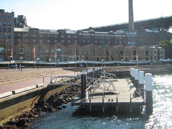 Wooden pier along Circular Quay waterfront, Sydney, with brick warehouses behind