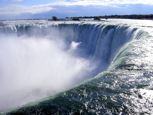 Niagara Falls, water plunges in a horseshoe curve amid spray and mist