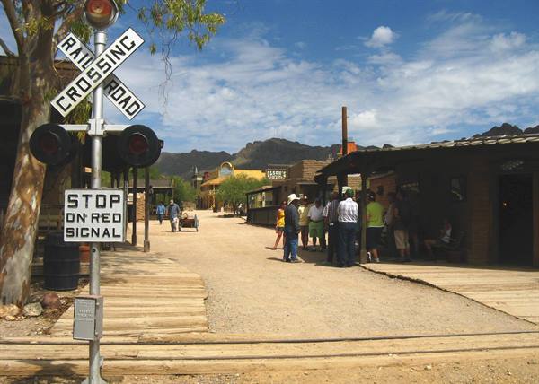 Vecchia cittadina western in legno con segnale ferroviario e turisti