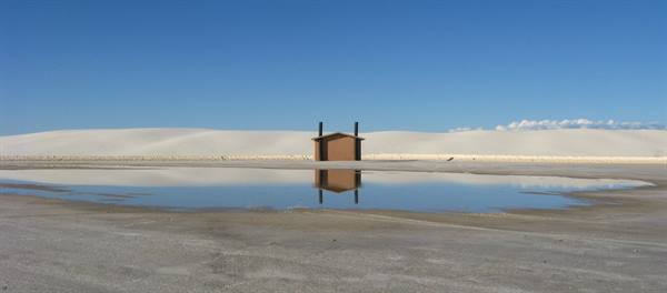 Riflesso di una capanna nell'acqua tra le dune bianche di White Sands