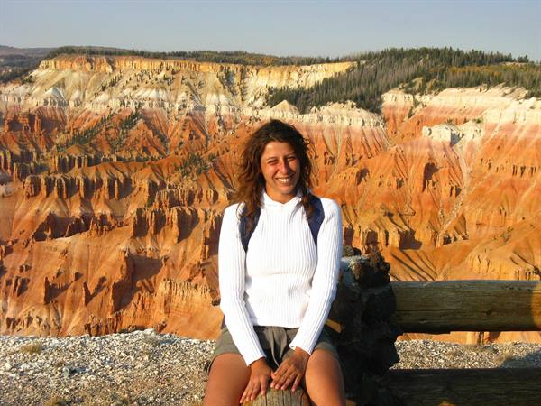 Sorridente sul tronco davanti alle hoodies arancioni di Cedar Breaks