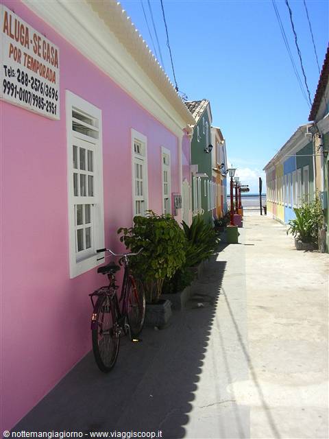 Bicycle against pink house, colorful houses along the beach