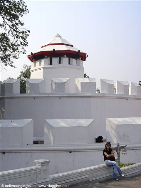 Tourist sitting on the white wall of Phra Sumen Fort, Bangkok