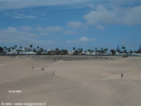 Maspalomas sand dunes with tourists walking among the ridges