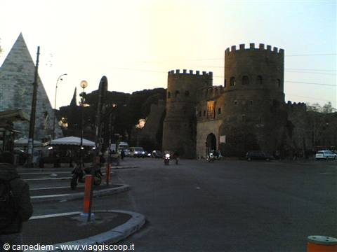 Porta San Paolo and Pyramid of Caius Cestius in Rome at dusk, traffic