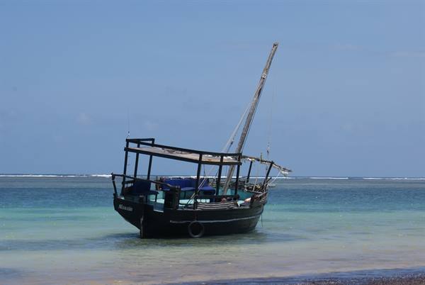 Wooden dhow anchored in shallow turquoise water