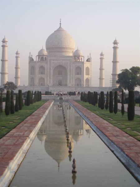 The Taj Mahal reflected in the central pool, flanked by cypresses and white marble