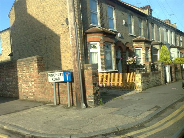 Finchley Road sign at a corner of brick terraced houses in London