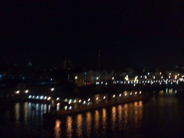 Night lights reflected on river water, illuminated waterfront embankment