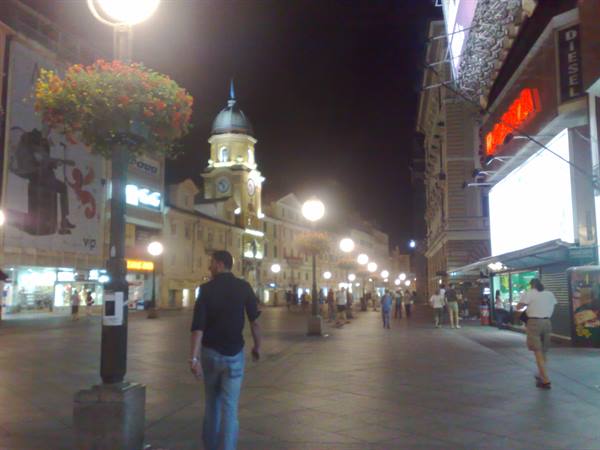 Night stroll on Rijeka's Korzo, clock tower glowing among streetlights and shop signs