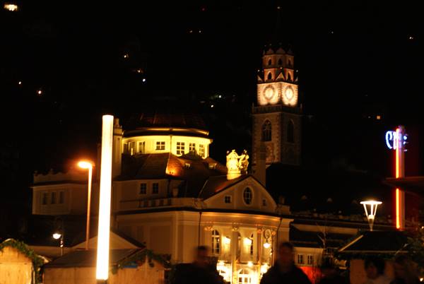 The illuminated Kurhaus at night with the abbey bell tower, Merano