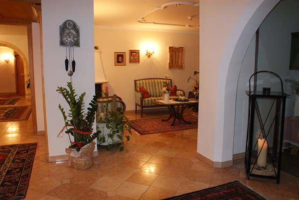 Hotel lounge with striped sofa, rugs, pendulum clock and candle lantern