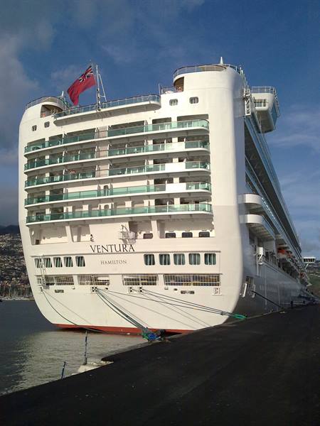 Cruise ship Ventura moored at the port, red flag waving