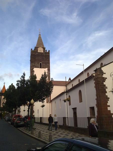 Funchal Cathedral, stone bell tower under streaky clouds