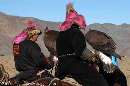 Hunters on horseback carrying golden eagles, traditional fur hats, arid mountains