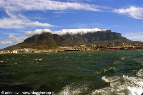 Table Mountain over the city, clouds on the flat top, choppy sea