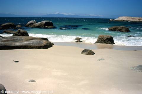White sand and rounded granite boulders among turquoise waves at Boulders Beach