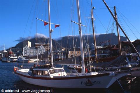 Sailing boat moored at Victoria & Alfred Waterfront, Table Mountain cloud-covered behind