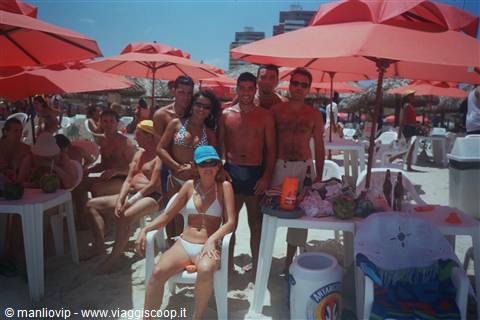 Group of friends under red umbrellas on Ipanema beach