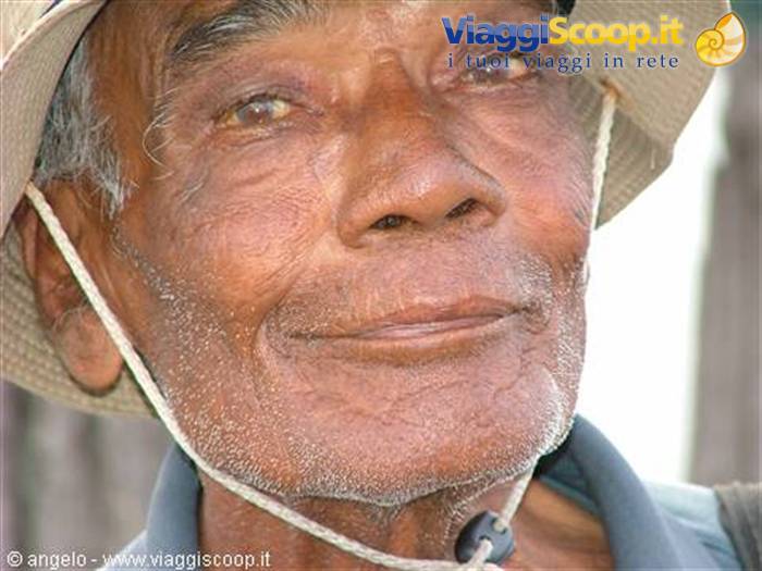 Wrinkled face of an elderly man wearing straw hat, natural light