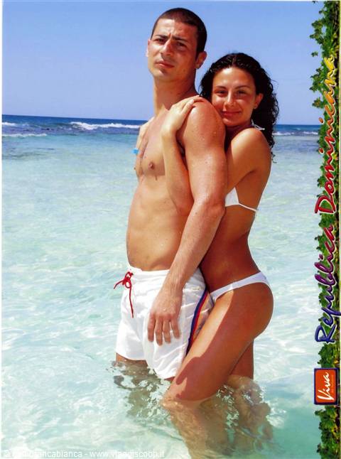 Couple in clear turquoise sea, white swimwear, bright sun, Dominican Republic