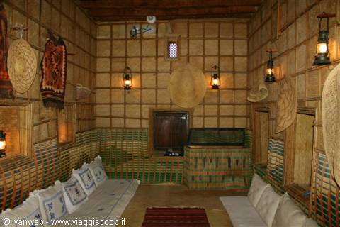 Traditional mud-brick house interior, lit lanterns and cushions along the walls