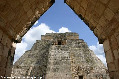 Pyramid of the Magician at Uxmal framed by a Maya stone arch
